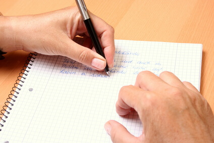 Ergotherapie: Linkshänder schreibst mit Stift auf Papierblock