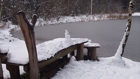 Geforener Silbersee mit Schneemann auf einem Steg