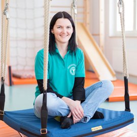 Ergotherapeutin Julia Walter auf einer Therapieschaukel im Motorikraum